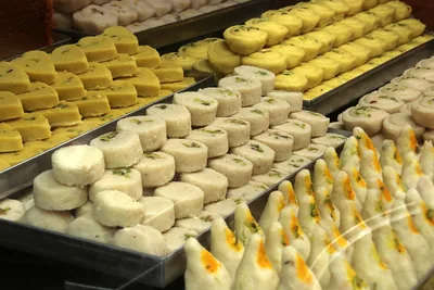 Trays of white and yellow milk sweets in a sweet shop