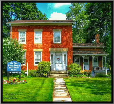 A red brick house with a green lawn and a path to the door