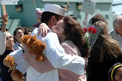 A sailor and a woman hugging at a homecoming