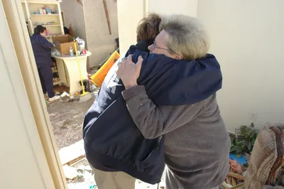 Two women hugging outside a house