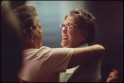 An old photo of two old friends embracing at a reunion