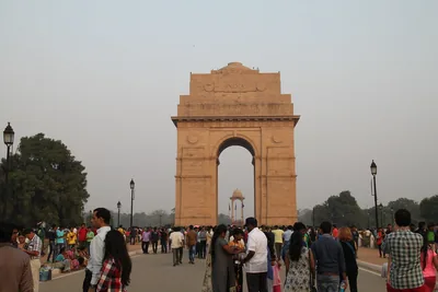Crowds of families walking on the lawns in front of India Gate