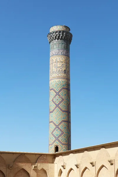 A tall minaret covered in blue and green tiles