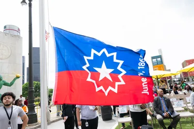 The red, white and blue Juneteenth flag with its white star flying on a pole