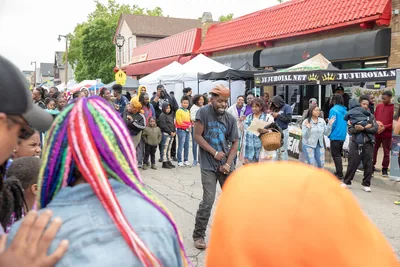 A crowd walks among stalls and tents at an outdoor street festival