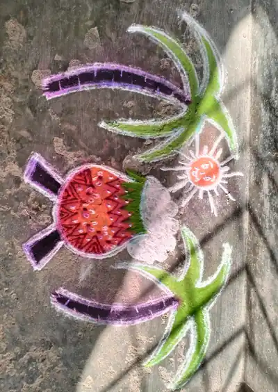 A colourful kolam with a pongal pot and sugarcane drawn on the ground