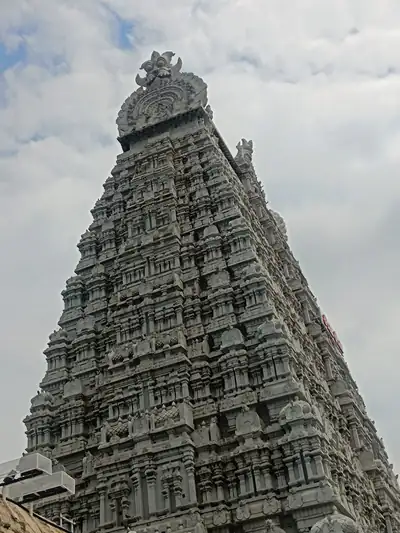 A tall carved stone temple tower against a cloudy sky