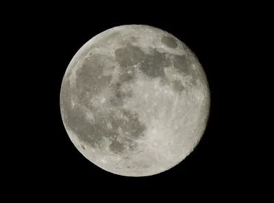A bright full moon in a black night sky