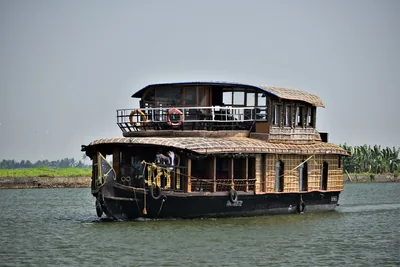 A two-storey houseboat cruising on a wide lake