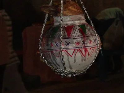 A decorated clay pot hanging from ropes, ready for Dahi Handi