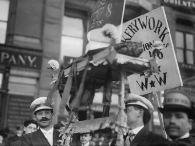 Bakery workers holding banners and flags in an old parade