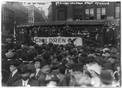 A crowd of families around a bus in an old street parade