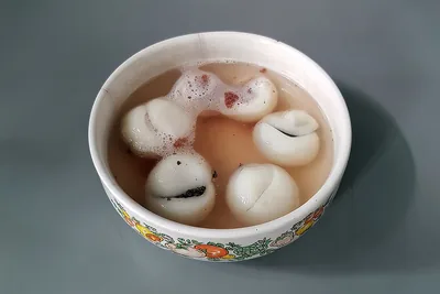 A bowl of white sweet rice balls in a light soup