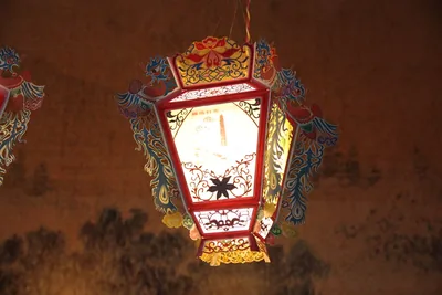 A painted hexagon lantern glowing in the dark
