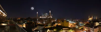 A city skyline at night with lit domes and minarets