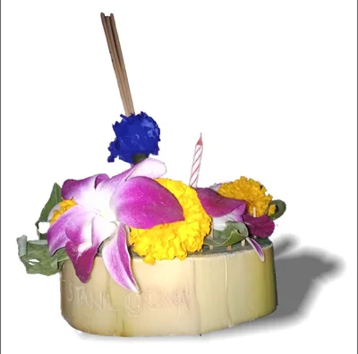 A small krathong of banana leaf with orchids, marigolds, a candle and incense sticks