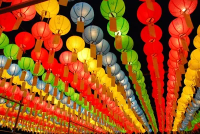 Rows of red, yellow, green and blue paper lanterns hanging overhead