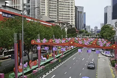 A city avenue lined with red arches and colourful new year decorations