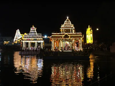 Temple floats glowing with lights on a temple tank at night