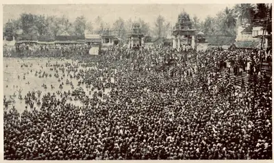 Old photo of thousands of pilgrims at the Mahamaham tank with temple towers behind