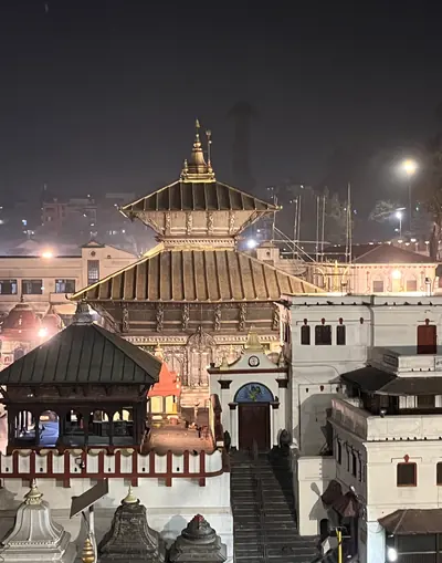 The golden roof of a pagoda temple lit up at night
