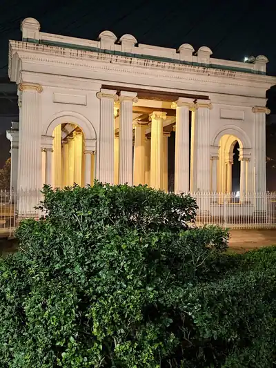 A white colonnaded riverside monument lit up at night