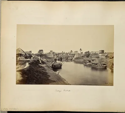 An old photograph of boats along a canal with buildings on the banks