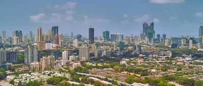 Wide view of the Mumbai skyline with green trees