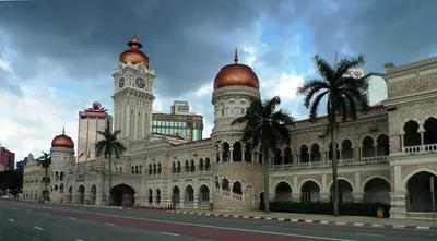 The Sultan Abdul Samad Building with its clock tower and domes under cloudy skies