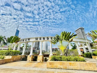 A garden gateway with palm trees and arches under a blue sky