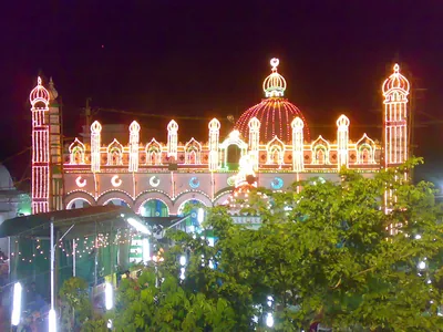 A mosque outlined in colourful lights at night
