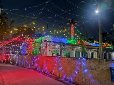 Strings of coloured lights over a street outside a mosque at night