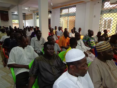 People sit together in a hall listening to a talk