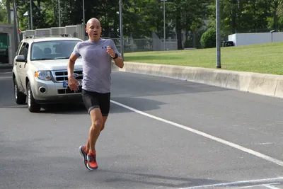 A man running along a road on a sunny day