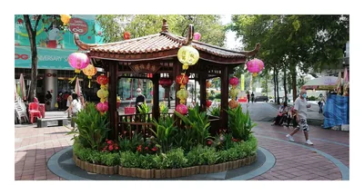A garden pavilion hung with lanterns among green plants