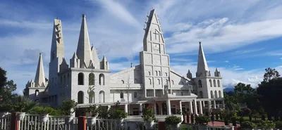 A white church with tall spires in Aizawl under a blue sky