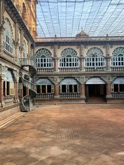 A palace courtyard with arched windows and a glass roof