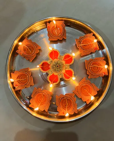 Painted clay lamps set in a circle on a steel plate