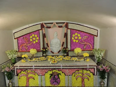 A flower decorated shrine with a picture of Swami Vivekananda