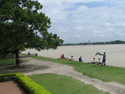 People resting on the green bank of the Ganga river