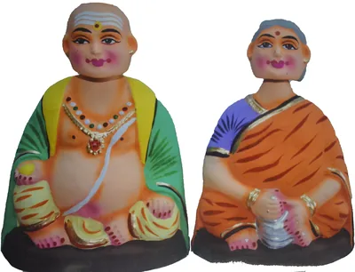 A pair of clay dolls of a smiling couple in bright clothes
