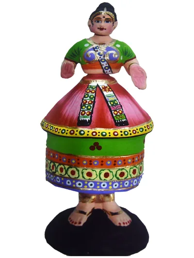 A painted wooden doll of a dancing woman in a green and red dress