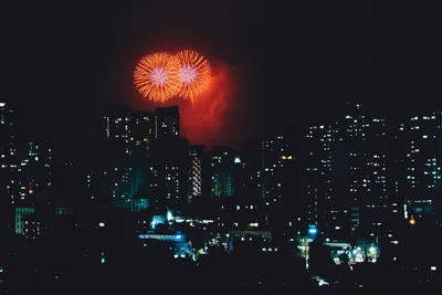 Red fireworks over tall city buildings at night