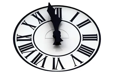 A clock face with the hands almost at midnight