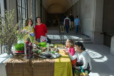 Visitors around a public haft-sin display in a long hallway