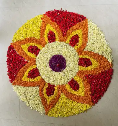 A flower carpet shaped like a bloom in red, orange and yellow petals
