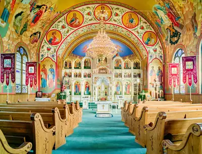 The colourful painted interior of an Orthodox church with a golden chandelier