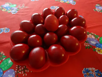 A plate of eggs dyed deep red on a festive cloth