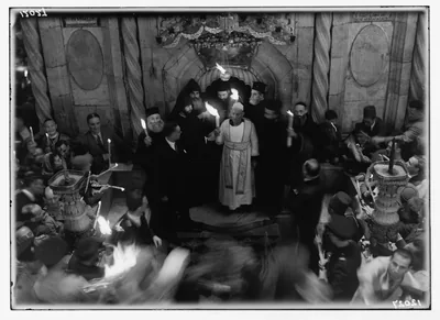 Black and white photo of clergy and crowds inside an old church