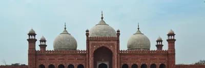 Red sandstone gateway and white marble domes of a grand mosque